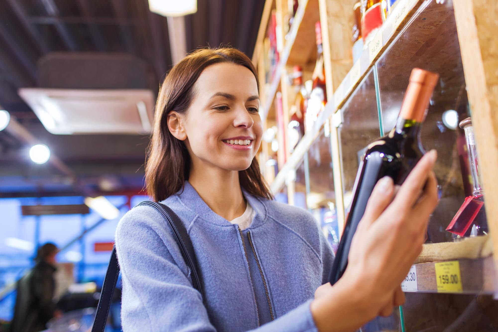 sale shopping consumerism people concept happy young woman choosing buying wine market 380164 89919